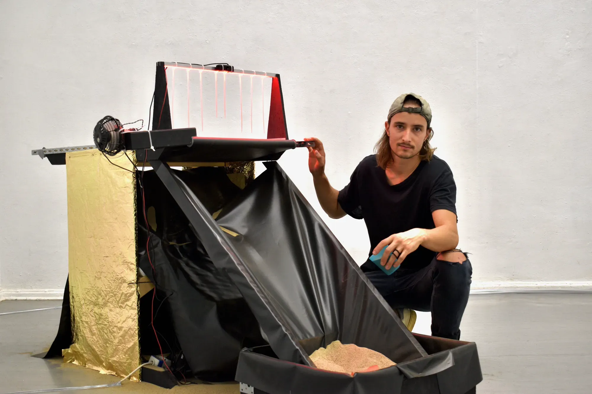 Artist posing alongside the installation